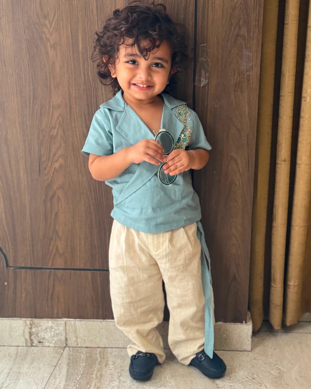 The teal kurta tied at the side, its embroidered placket running down from the collar