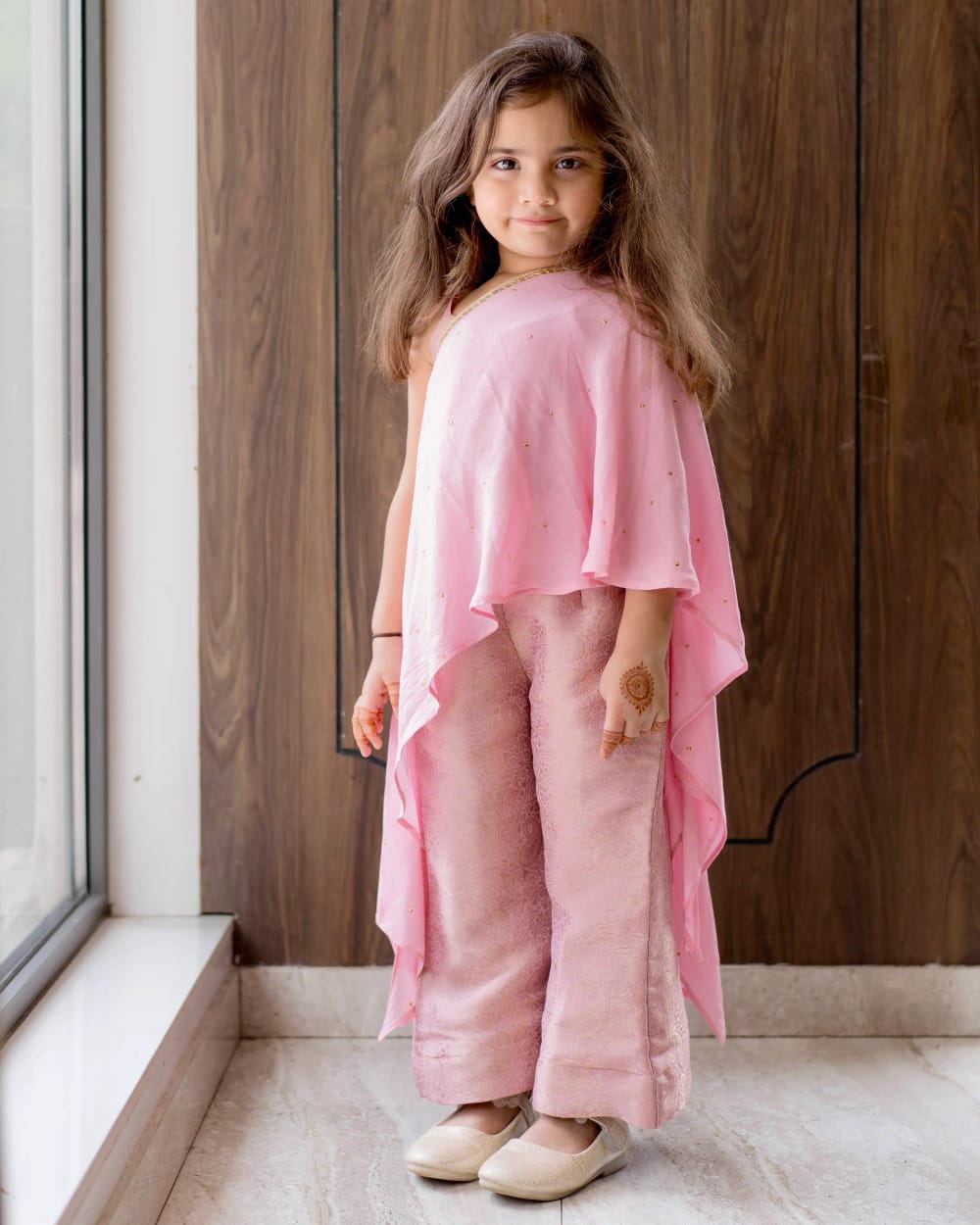 The pink cape top and shimmering trousers at full length