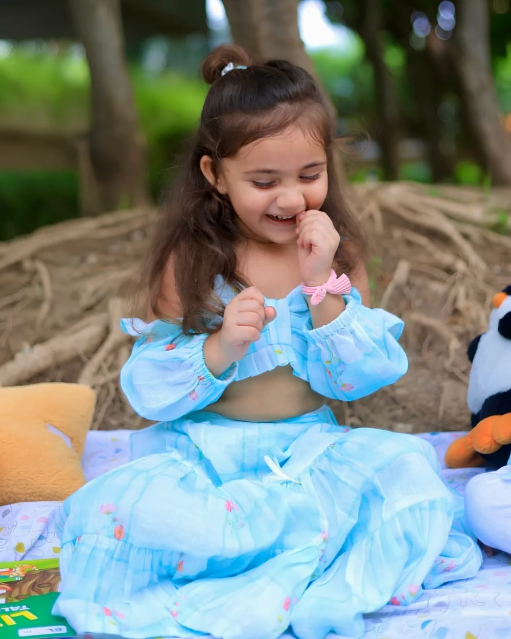 A girl in a pale blue off-shoulder top and matching gathered skirt
